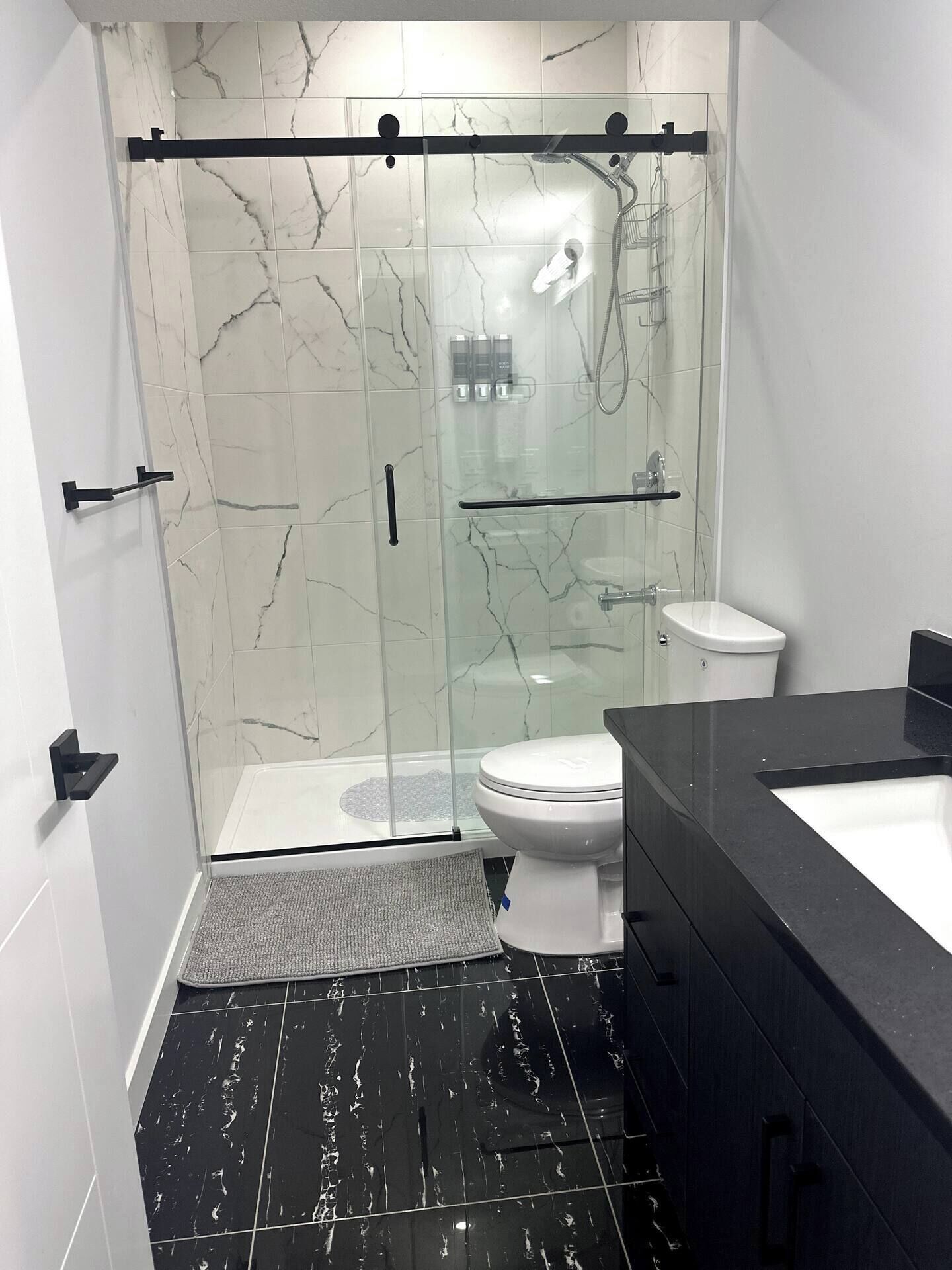 Ein modernes Badezimmer mit einer Duschkabine, einer Toilette und einem Waschbecken mit Waschtisch.
