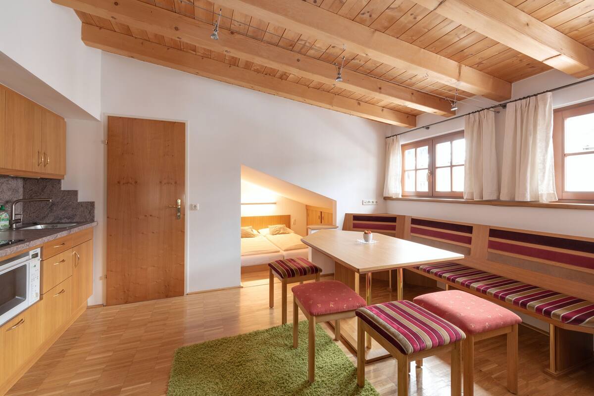 A compact kitchen with wooden cabinets and a built-in microwave.