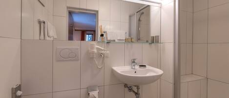 Un baño moderno con inodoro, lavabo y ducha.