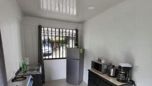 A small, clean kitchen with a refrigerator, microwave, and coffee maker.