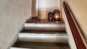 Una escalera con paredes blancas y un arco de ladrillo.
