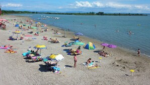A beach with numerous umbrellas and people sunbathing. - Mobile home with table tennis and pool (Belvedere)