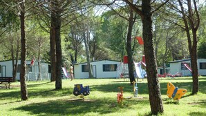 A campground with RVs, a playground, and a picnic table. - Mobile home with table tennis and pool (Belvedere)