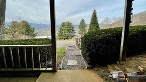 A covered porch with a view of a gravel path leading to a road, surrounded by trees and a hedge. - Delightfully rustic 4-bedroom house in Vilas with stunning long-range views. (Vilas)