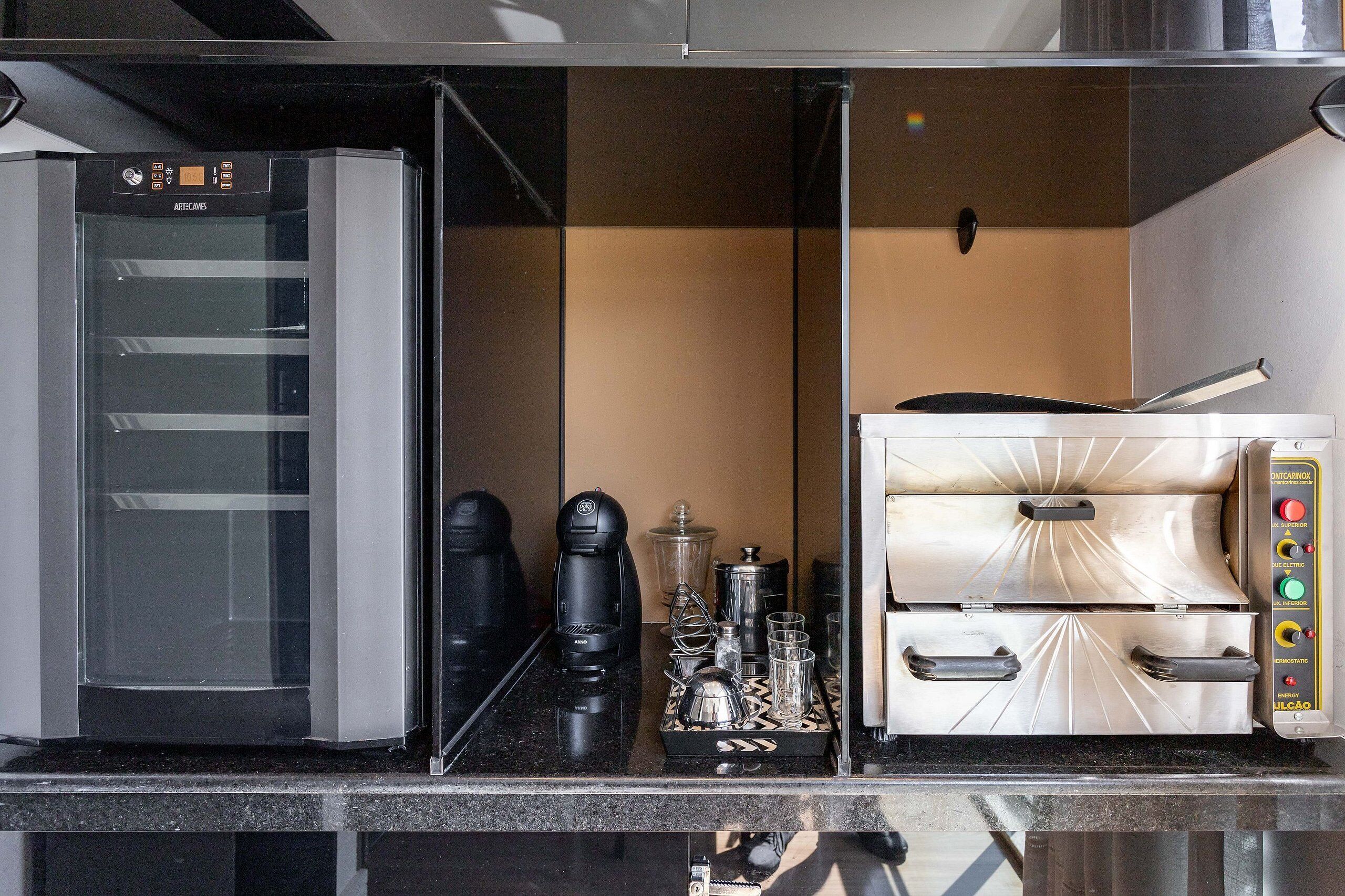 A commercial kitchen with a coffee machine, espresso machine, and various kitchen utensils.