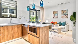 A modern kitchen with a wooden island, a built-in oven, and a large window. - Wariruri Condos by SunStays (Noord)