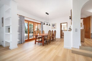 A dining area with a wooden table and chairs, a staircase, and a view of the outdoors. - Villa Zahara - paceful retreat in the countryside (Alcúdia)