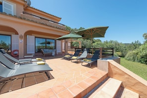 Une villa dotée d’un espace extérieur aménagé, d’une piscine et offrant une vue sur le paysage environnant.