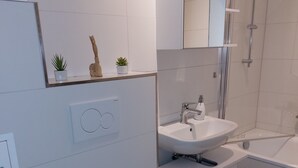 Un bany modern amb vàter, rentamig i dutxa.