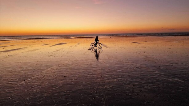 A beach scene with a person riding a bicycle. - Maison Sainte Cécile near beach and shops, pets welcome (Camiers)