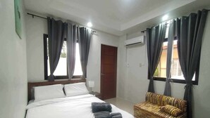 A bedroom with a bed, a sofa, and curtains. - 3 Bedroom Exclusive Gated Home in Manila (Las Piñas)