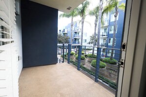 A balcony with a view of a residential area, including palm trees and a blue building. - Wi-Fi • Parking • Fully Furnished 1BR in San Diego (San Diego)