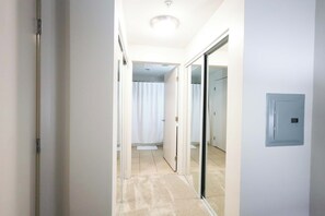 A corridor with a sliding glass door leading to a bathroom with a shower curtain.