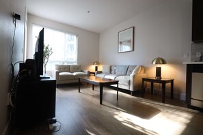 A modern living room with a sofa, a coffee table, and a TV.