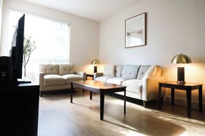 A modern living room with a sofa, two armchairs, a coffee table, and a television. - Wi-Fi • Parking • Fully Furnished 1BR in San Diego (San Diego)