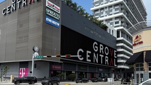 A modern building with "GROVE CENTRAL" signage, a Target store, and a pizza restaurant. - Lovely 2-bedroom house with AC in vibrant Miami (Miami)