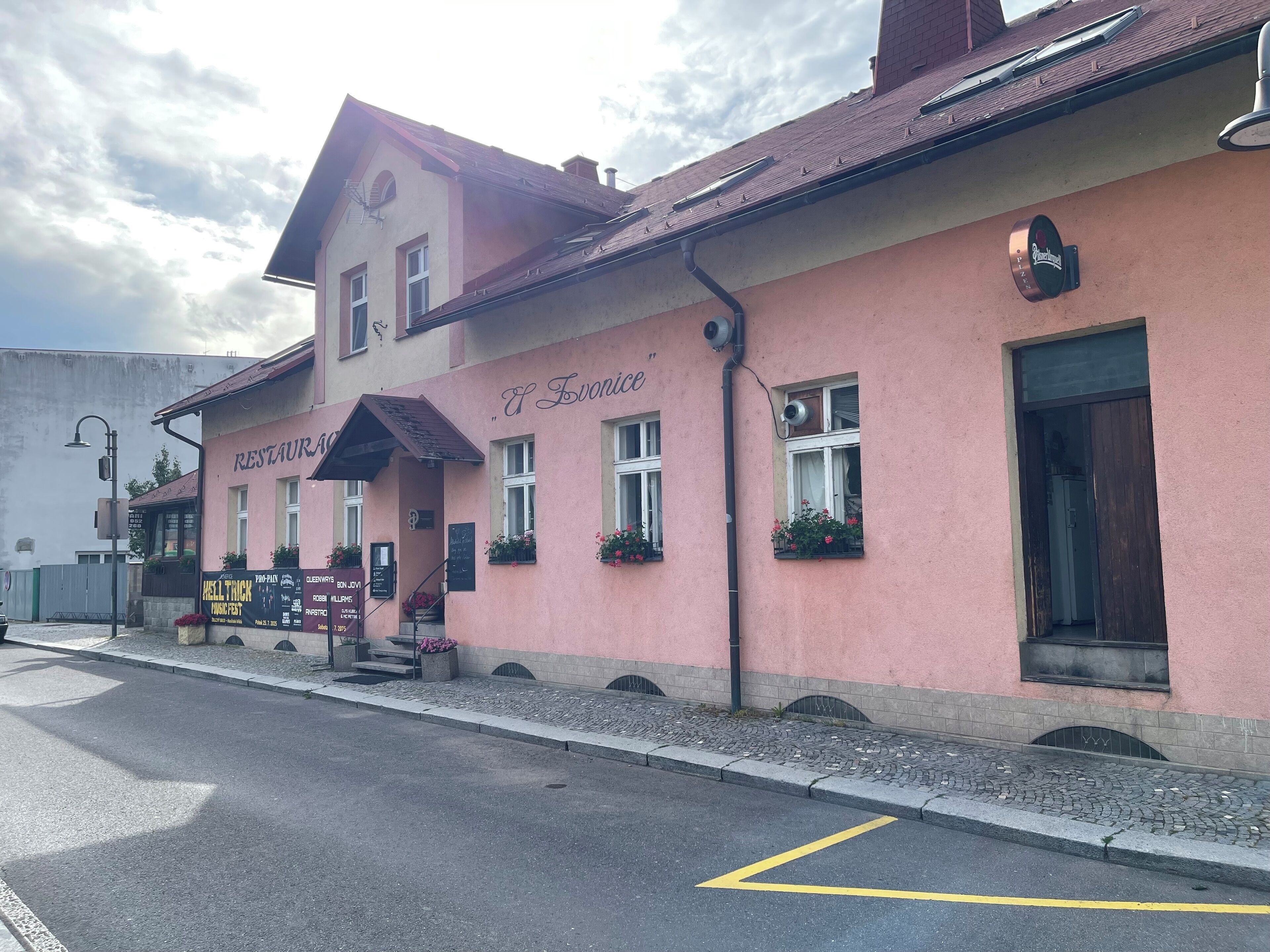 Un bâtiment rose avec une enseigne indiquant « RESTAURANT et bar ».