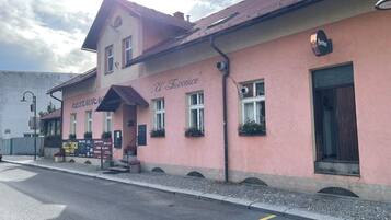 Un bâtiment rose avec une enseigne indiquant « RESTAURANT et bar ».