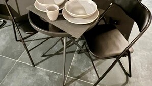Een eettafel met vier borden, twee kommen en twee bekers.