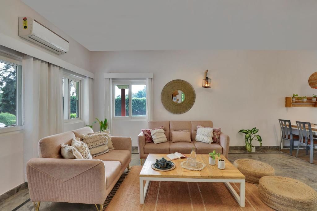 Een woonkamer met een bank, fauteuil, salontafel en een eethoek met stoelen en een tafel.