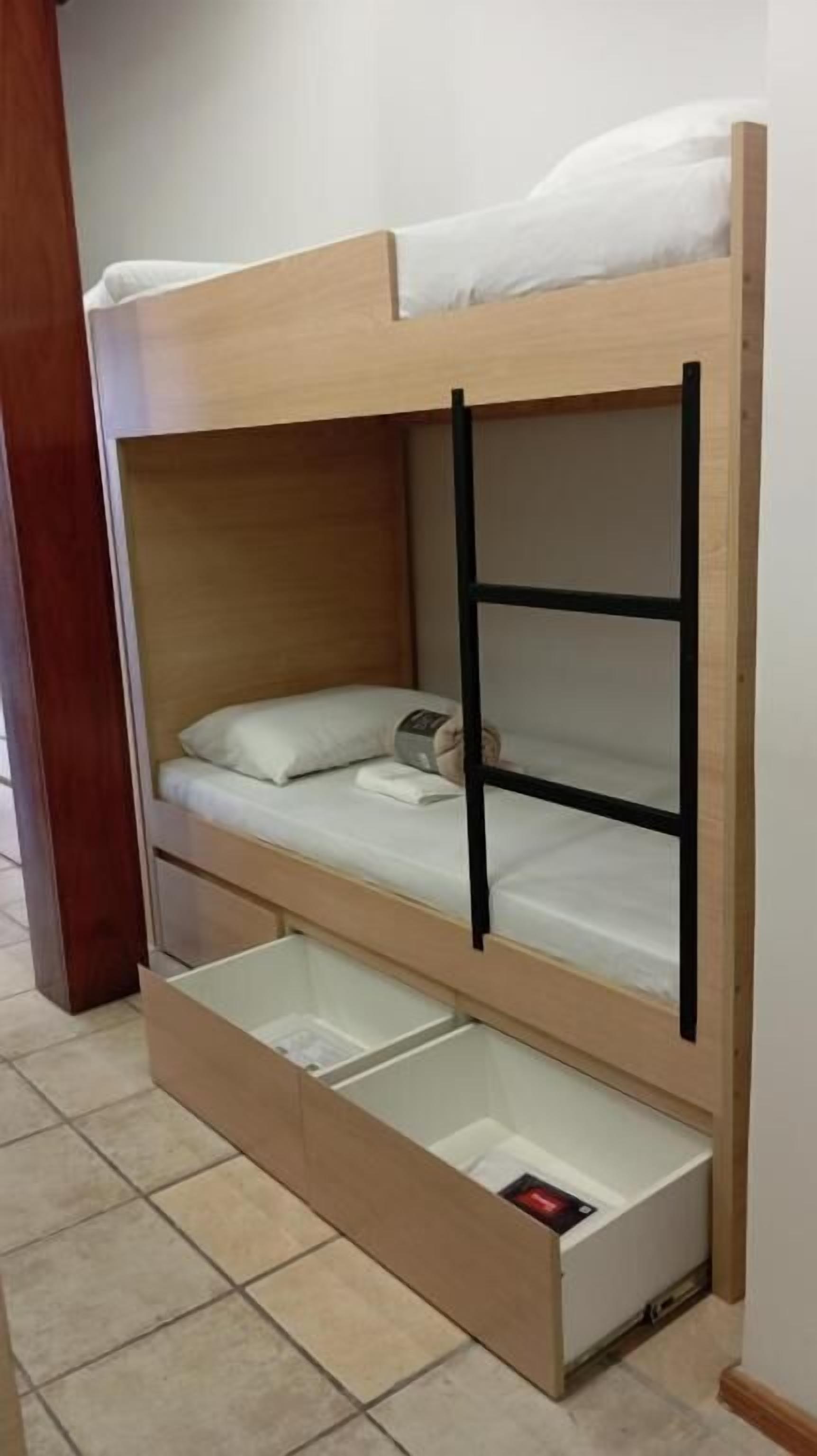 A bunk bed with a lower bunk and a pull-out drawer below.