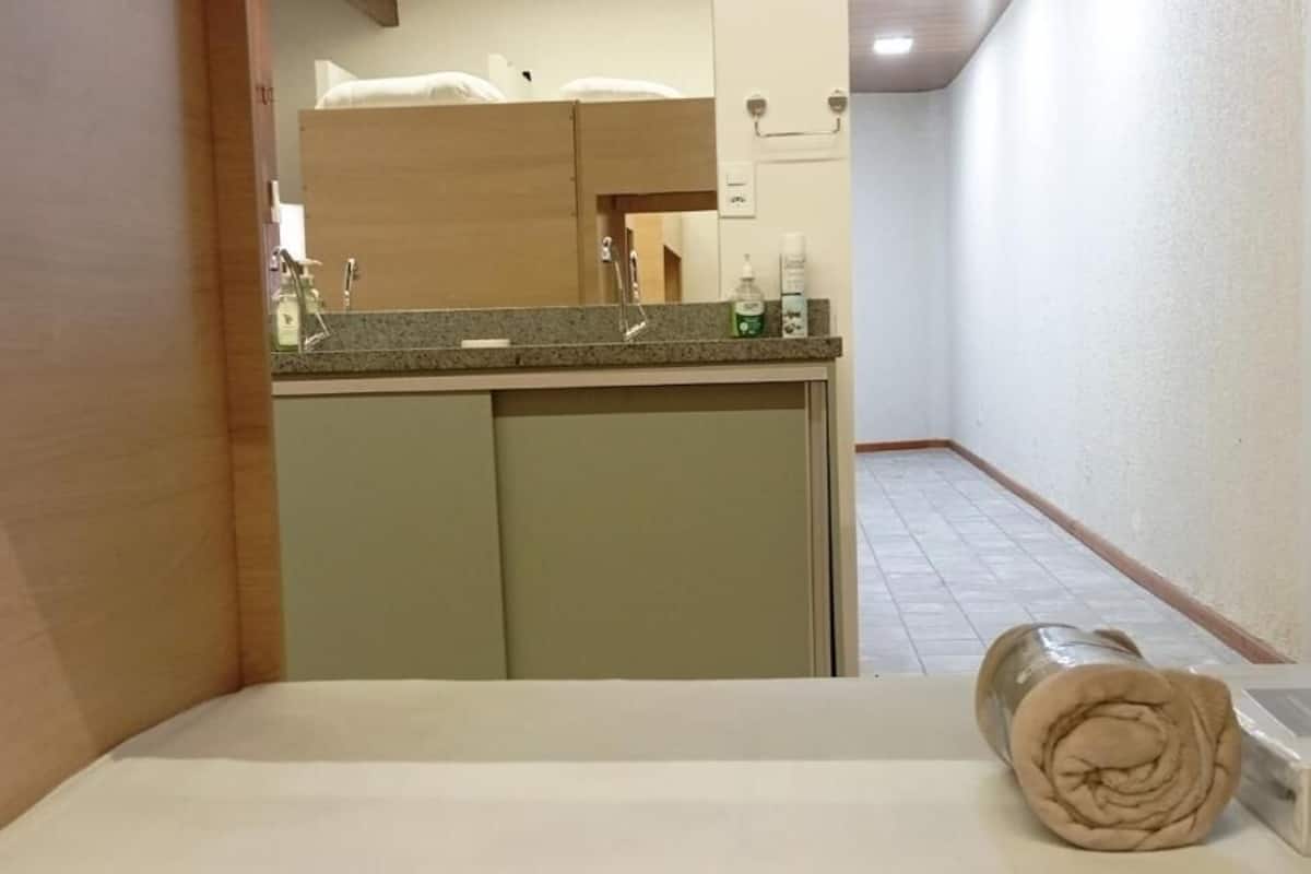 A bathroom with a sink, mirror, and toiletries.