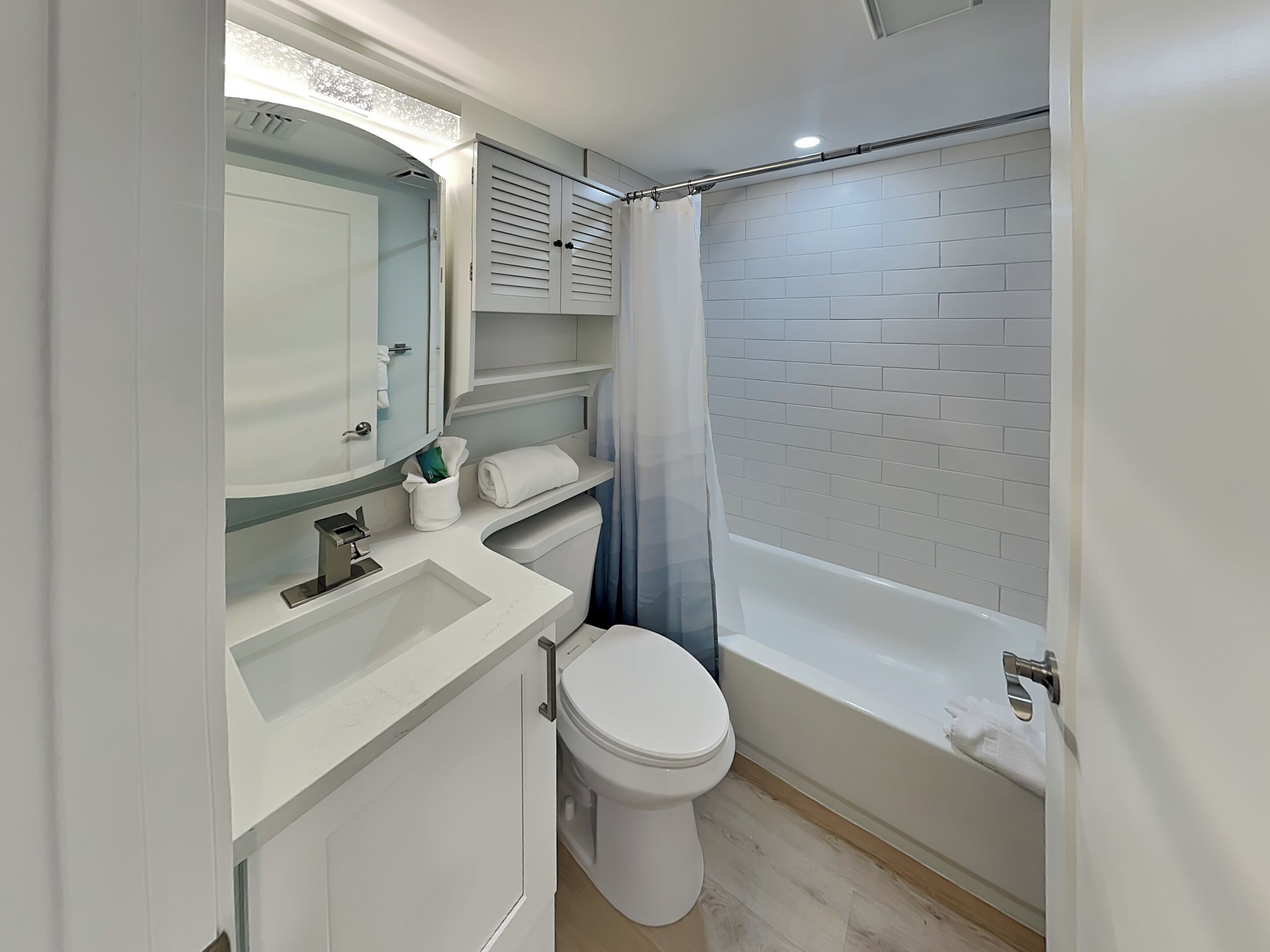 Un baño moderno con lavamanos, inodoro y bañera blancos.