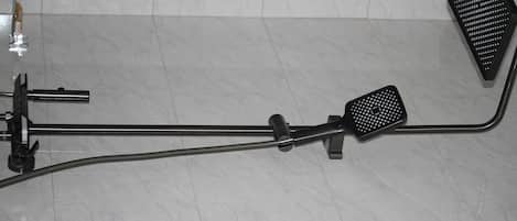 Une salle de bain équipée d’un pommeau de douche, d’un flexible de douche et d’une brosse à main.