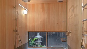 Interior de madera con una ventana, un farol de piedra y una zona de ducha.