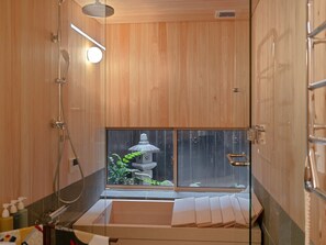 Interior de madera con una ventana, un farol de piedra y una zona de ducha.