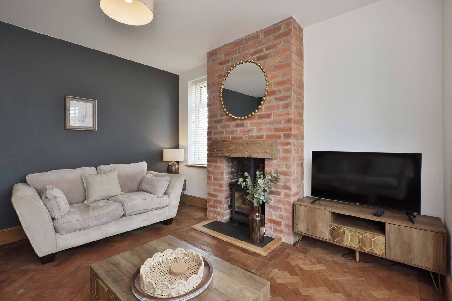A living room with a brick fireplace, a sofa, a television, and a coffee table.