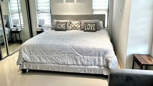 Ein Schlafzimmer mit einem großen Bett, zwei Nachttischen, einem Spiegel und Bildern an der Wand.
