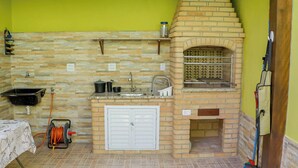 Una cucina compatta con forno a mattoni, un lavello e un piccolo ripiano.