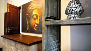 Una encimera de madera con una pintura de Buda, una lámpara y una puerta.