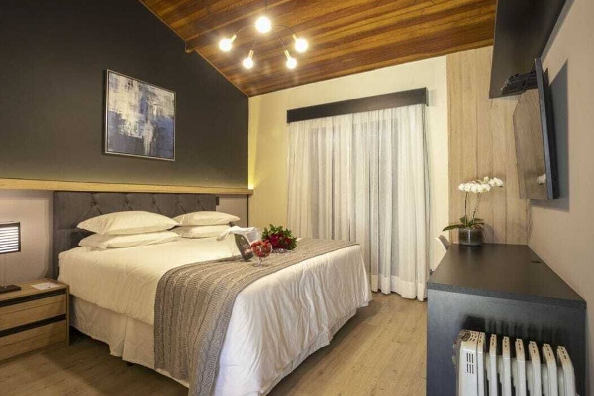 A bedroom with a bed, bedside table, lamp, and a radiator.