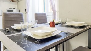 A dining area with a table set for two, including plates, glasses, and cutlery.