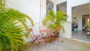 A small outdoor patio with a table and chairs, surrounded by potted plants. - Luz Collection 3bedroom San Juan (San Juan)