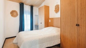 Une chambre à coucher avec un lit, une armoire en bois et un élément de décoration circulaire fixé au mur.