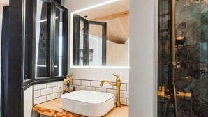 A bathroom with a white sink, gold faucet, and a large mirror. - Le Chai des Tortues · Character home · Beach 250 m (Rivedoux-Plage)