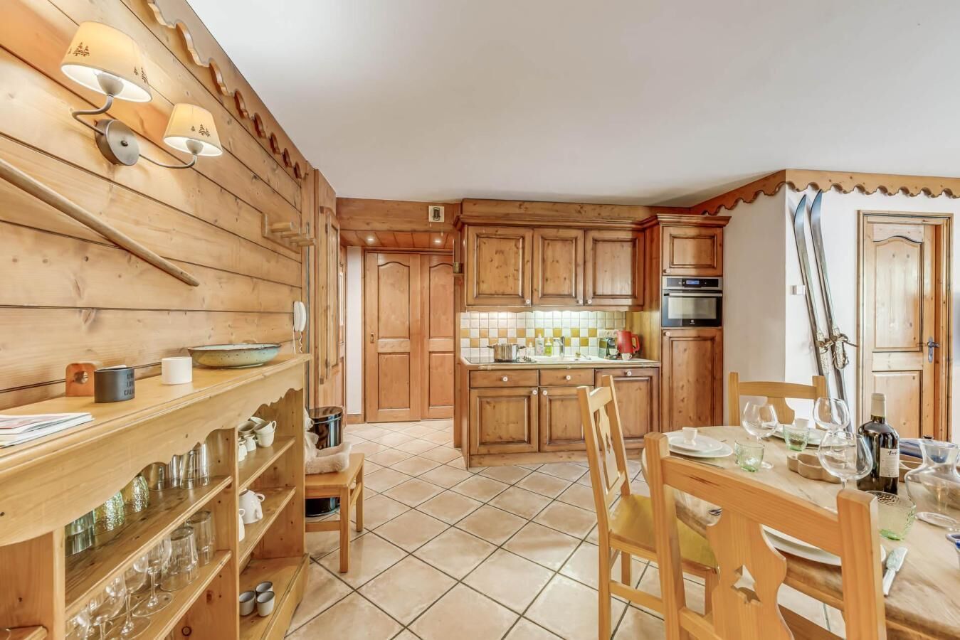 Interior de madera con cocina, mesa y sillas.