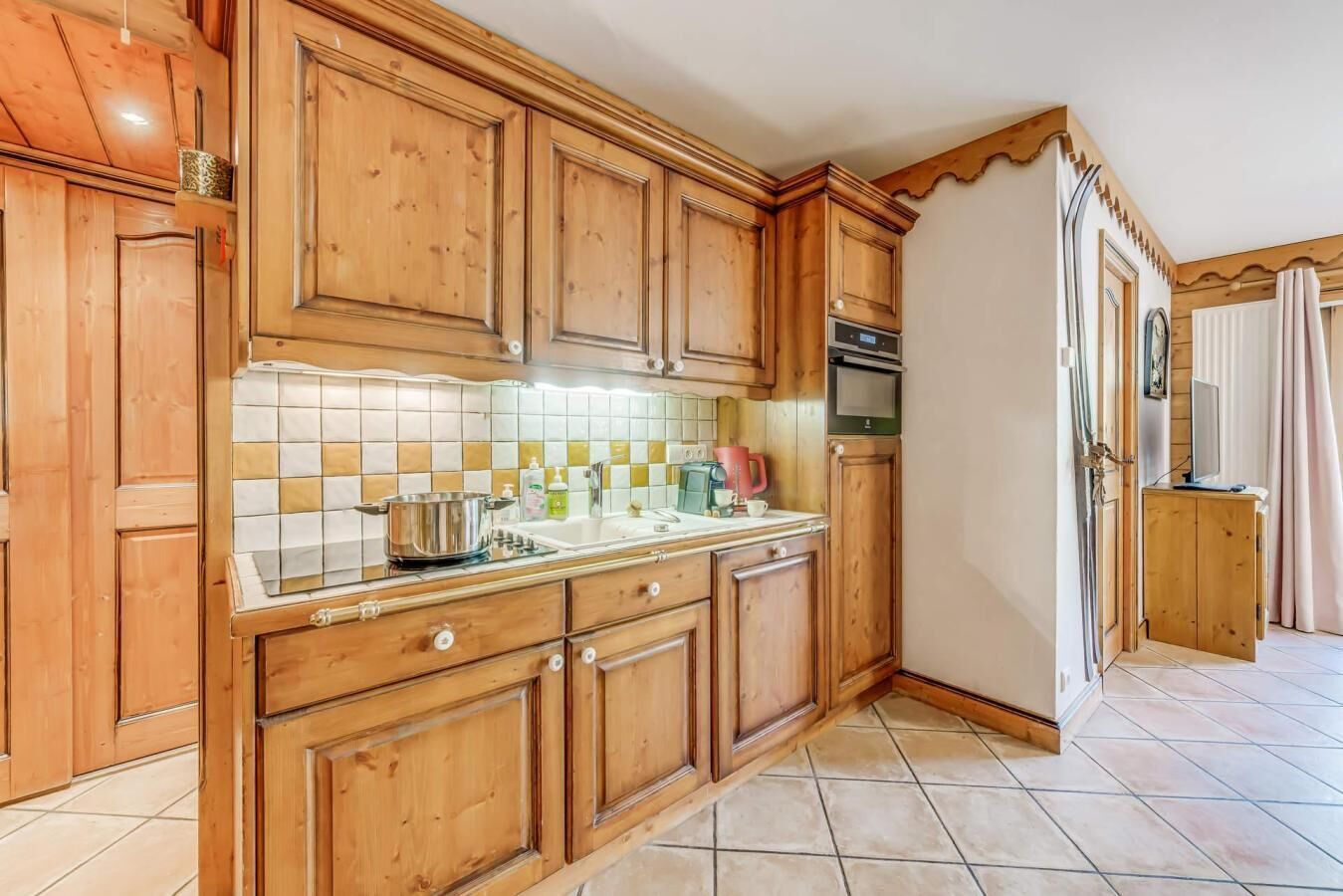 A kitchen with wooden cabinets, a tiled backsplash, a sink, a stove, and a microwave.