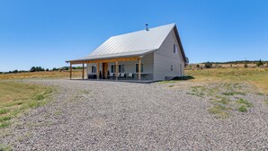 A single-story house with a covered porch, a chimney, and a gravel driveway. - Between Bryce Canyon & Zion: Hiker's Paradise! (Hatch)