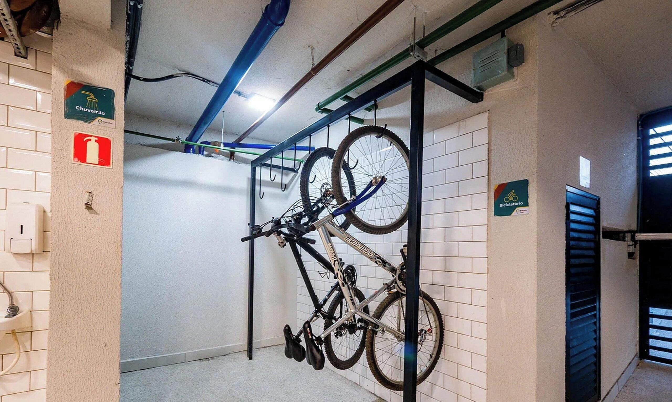 A bike rack with a bicycle and a fire extinguisher sign on the wall.