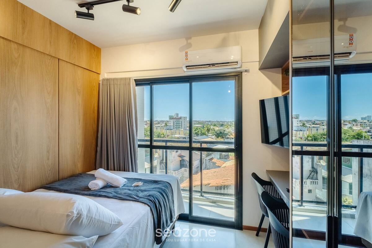 Une chambre d’hôtel moderne avec un grand lit, une tél évision et une vue sur la ville.
