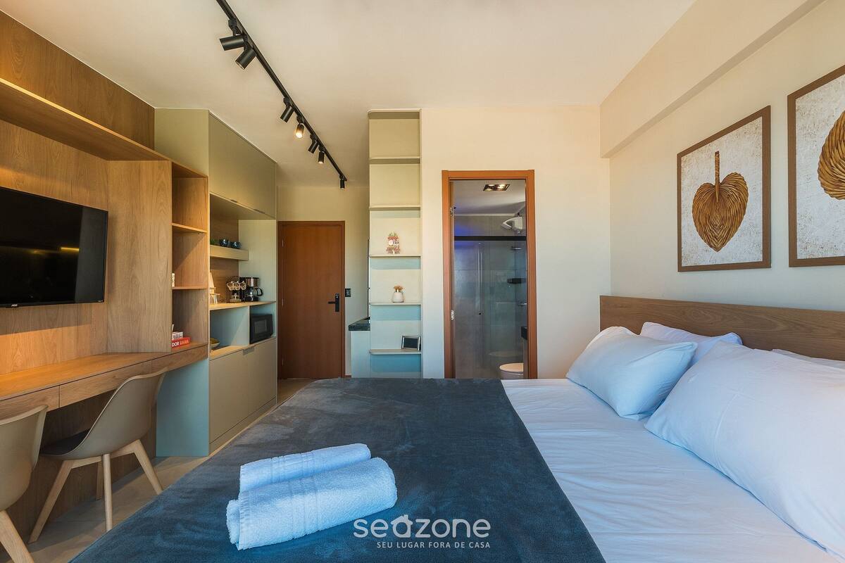 Une chambre d’hôtel moderne équipée d’un lit, d’un bureau et d’une télévision.
