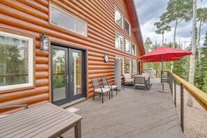 A wooden cabin with a deck, outdoor seating, and a red umbrella. - Hot Tub, Game Room! 3-Story Brian Head Home (Brian Head)
