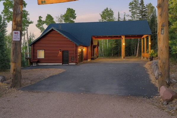 A log cabin with a covered porch and a driveway leading to the entrance. - Hot Tub, Game Room! 3-Story Brian Head Home (Brian Head)