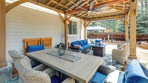 A covered outdoor patio with a wooden table, wicker furniture, and a ceiling fan. - Less Than a Mile to Forest Roads/Trails (Flagstaff)