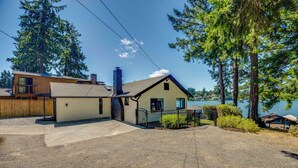 A two-story house with a garage, a chimney, and a view of a lake.
