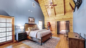 A bedroom with a wooden ceiling, a bed, a nightstand, a desk, and a chair. - Creek Access, Games: Family-Friendly Royal Retreat (Royal)